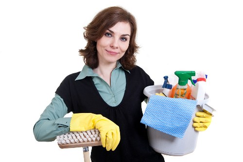 Technician vacuuming upholstered furniture during cleaning